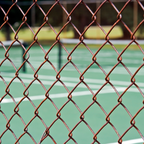 Picture of chain link fence in front of tennis court